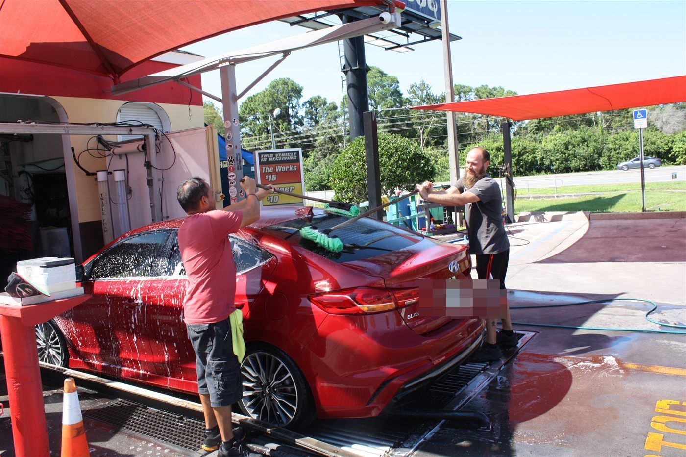 Wow Express crew hand-washing a car at the Trinity, FL shop
