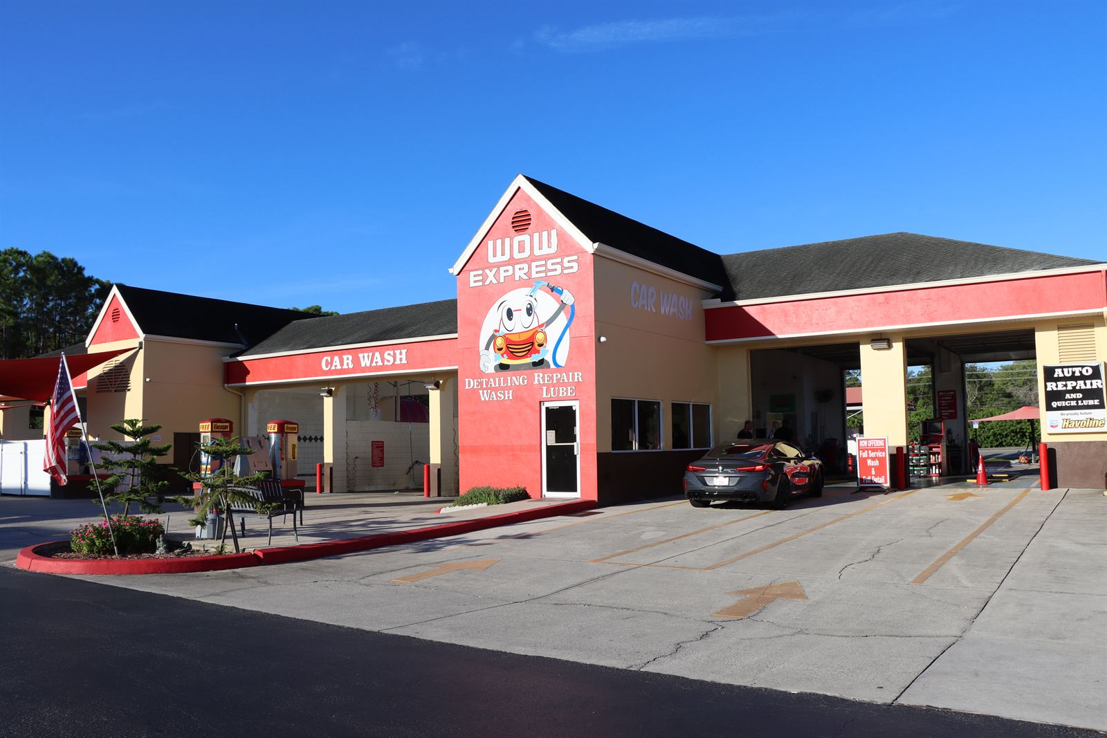 A sports car pulling into the Wow Express car wash on a sunny Florida day